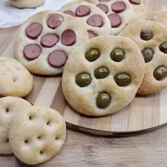 Focaccine di semola con olive e wurstel, pronte per essere gustate.