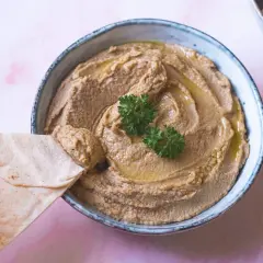 Krämig hummus utan tahini, perfekt att dippa pitabröd i. Garnerad med persilja och olivolja.
