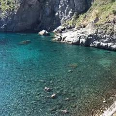 Acque cristalline e scogliere a picco a Ischia. Un angolo di paradiso dove la spiaggia incontra l'acqua calda, invitando al relax.