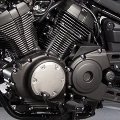 Silnik V-twin motocykla Yamaha XV950, z charakterystycznymi żebrowanymi cylindrami i czarnymi osłonami.