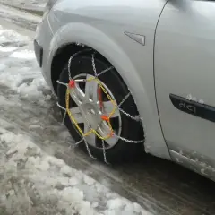 El coche está en la nieve, listo para circular cuando se ponen las cadenas de nieve.