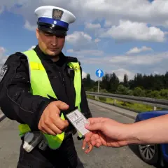 Policjant w kamizelce odblaskowej prosi o okazanie dokumentów. Czy trzeba mieć przy sobie prawo jazdy? Tak, podczas kontroli drogowej.