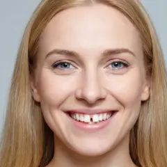 Uśmiechnięta blondynka z wyraźną szparą między zębami, która jest widoczna nawet przy krótkim wędzidełku.
