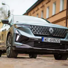 Nowy Renault Espace 2024 z charakterystycznym grillem i nowoczesnymi światłami LED, zaparkowany na brukowanej ulicy.