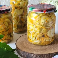Słoiki z pyszną sałatką z ogórków, marchewki i cebuli na zimę. Idealna do słoików, by cieszyć się smakiem lata przez cały rok.