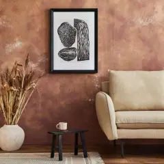 Rusty, textured wall – świetny pomysł co na ścianę zamiast farby. Obok kanapa, grafika i suszone trawy.