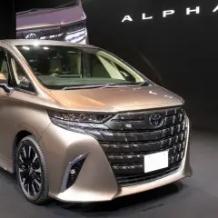 Elegancki, brązowy Toyota Alphard prezentuje się na czarnym tle.