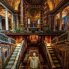 Interno della chiesa San Pietro a Roma, con scale marmoree, mosaici dorati e un altare imponente.