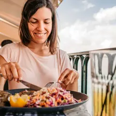 Frau genießt Fisch mit Salat, eine Mahlzeit, die gut zur pescetarier bedeutung passt.
