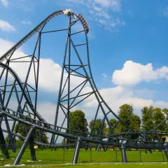 Kolejka Hyperion pędzi z zawrotną prędkością, osiągając nawet 145 km/h. Widok na stalową konstrukcję i błękitne niebo.