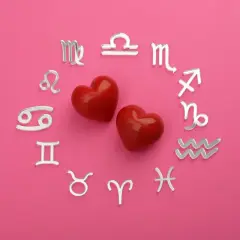 Dwa czerwone serca otoczone srebrnymi symbolami zodiaku. Dziś horoskop na dziś Waga miłosny zapowiada gorące uczucia.