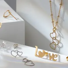Złota i srebrna biżuteria w kształcie serc i napisu "LOVE". Próby srebra i złota prezentują się elegancko.