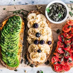 Trois toasts variés : avocat, banane-myrtille, tomates. Une alimentation riche en protéines pour bien commencer la journée.