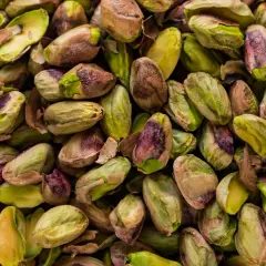 Mnóstwo łuskanych pistacji, zielonych i fioletowych. Czy pies może jeść pistacje? Lepiej nie ryzykować, bo mogą być szkodliwe.