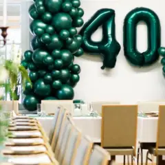 Elegancka impreza urodzinowa dla dorosłych z balonami tworzącymi liczbę 40. Uroczysty stół z zastawą i świecami.