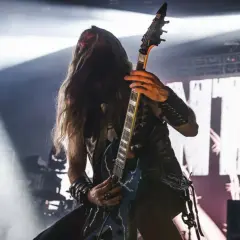 Pantera w Polsce: gitarzysta z długimi włosami gra na scenie, w tle wielki napis z nazwą zespołu.