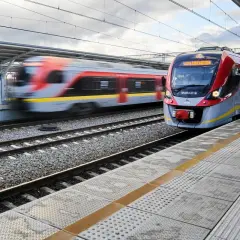 Nowoczesny pociąg PKP Intercity zbliża się do stacji Łódź Kaliska. W tle widać drugi pociąg w ruchu.