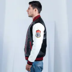 Man in profile wearing a black and white letterman jacket with red trim and a "Warrior" patch.
