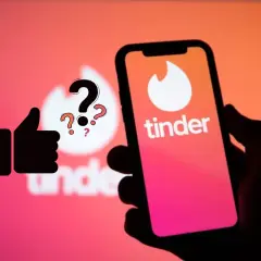 Kciuk w górę i znaki zapytania nad logo Tindera. Zastanawiasz się, tinder ile lajków dziennie?