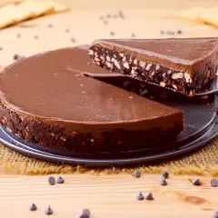 Torta al cioccolato con biscotti, un'idea per dolci velocissimi senza cottura. Una fetta viene sollevata con una paletta.