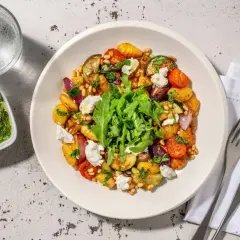 En härlig ugnsrostad grönsaksrätt med potatis, zucchini, tomater och lök, toppad med ricotta och pinjenötter. Ett perfekt ricotta recept för en lätt middag.