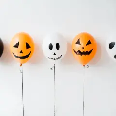 Fünf Ballons für Halloween basteln: ein schwarzer, zwei Kürbis-Ballons und zwei Geister-Ballons.