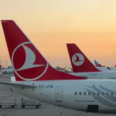 O zachodzie słońca samoloty Turkish Airlines czekają na pasażerów i ich bagaż.
