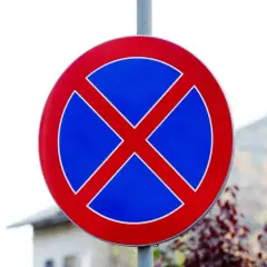 Znak drogowy informujący o bezwzględnym zakazie parkowania. Nie zatrzymuj się tutaj, bo to nielegalne!