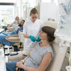 Eine Krankenschwester verbindet eine Patientin mit Infusion. Sie verträgt die chemo gut, ein gutes Zeichen.