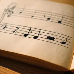 Feuilles jaunies d'un carnet de musique, notes dessinées à la main. Une mélodie suspendue, un demi soupir avant la prochaine mesure.