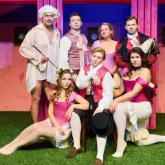 Aktorzy Teatru Capitol w barwnych strojach, przygotowani do występu.
