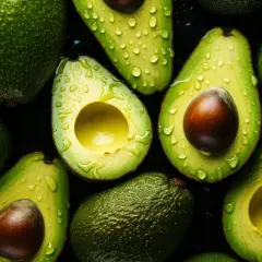 Aguacates frescos y jugosos, cortados y enteros, con gotas de agua, resaltando sus increíbles propiedades nutritivas.