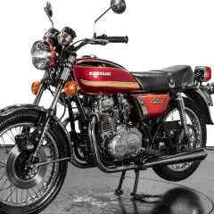 Clásica Kawasaki 400 antigua, roja y dorada, con motor expuesto y detalles cromados. Un icono de los 70.