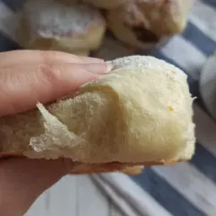 Morbida brioche con lievito madre, cosparsa di zucchero a velo, pronta per essere gustata con un caffè.
