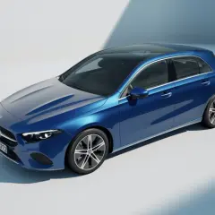 Un elegante Mercedes Clase A W177 azul metálico con techo panorámico, capturado en un estudio con iluminación suave.