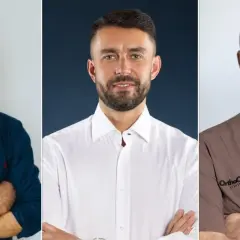 Trzech lekarzy w garniturach i fartuchach medycznych.