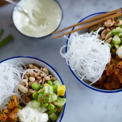 Två färgglada pokebowls med lax, grönsaker, nötter och risnudlar. Ett perfekt pokebowl recept för en hälsosam lunch.