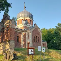 Cerkiew w Frysztaku z charakterystyczną kopułą, otoczona zielenią.