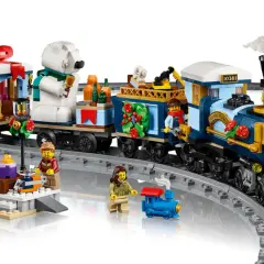 Der LEGO Weihnachtsexpress fährt mit Geschenken und einem Eisbären durch die Winterlandschaft. Figuren warten am Bahnsteig.