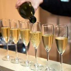Eine Flasche italienischer Champagner wird in eine Reihe von Gläsern eingeschenkt.