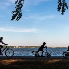 Dzieci na rowerach i hulajnogach nad jeziorem. Idealny rower dla 13 latka to taki, który zapewni mu radość z jazdy.