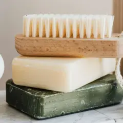 Jabón de azufre para que sirve: una pila de jabones y un cepillo de madera.