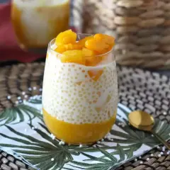 En glas med krämig mango sago, toppad med färsk mango. En tropisk dröm!