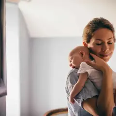 Matka tuli maleństwo, uspokajając je. Czasem warto poczekać, do kiedy odbijać dziecko, by zapewnić mu komfort.