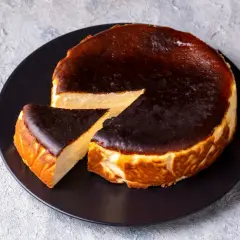 Pyszny sernik baskijski z przypaloną skórką, idealny do kawy. Zastanawiasz się, jak długo piec sernik, by był taki idealny?