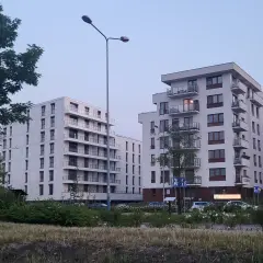Nowoczesne bloki mieszkalne z balkonami na tle błękitnego nieba.