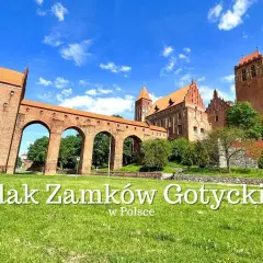 Gotycki zamek z cegły, część szlaku zamków krzyżackich, z charakterystycznym łukowym mostem i wieżą.