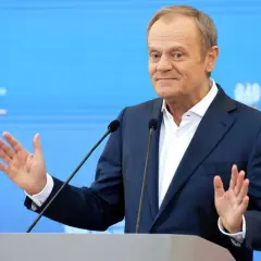 Donald Tusk przemawia, gestykulując. W tle logo Kancelarii Premiera. Czy zastanawiasz się, ile zarabia Tusk miesięcznie?