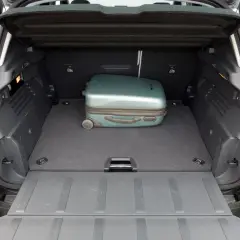 Otwarty bagażnik Peugeot 3008 z jednym zielonym walizką.