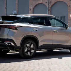 Nowy OMODA AUTO w miejskim otoczeniu, z charakterystycznym tyłem i czarnymi felgami.